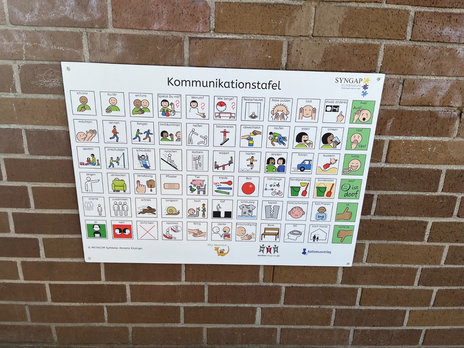 Spielplatztafel mit METACOM Symbolen an Mauer